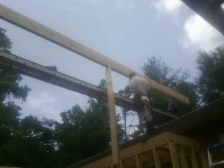 Carpenter setting a ridge beam over a new addition frame — Ice Dam Removal by Roofing Brothers in Coosawhatchie
