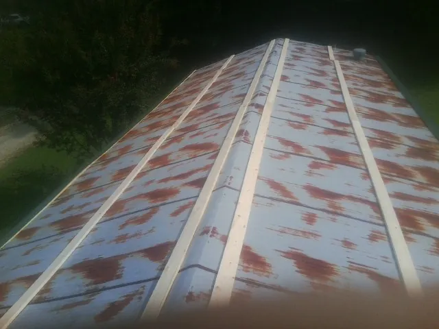 Rusted metal roof panels with new wood purlins before replacement — Storm Damage Roof Repair in Coosawhatchie by Roofing Brothers