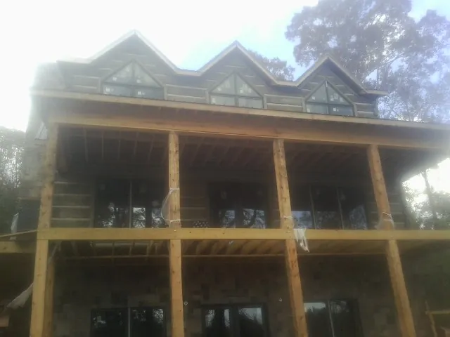 Dormers and porch framing on a large log home under construction — Roof Coating work by our crew in Coosawhatchie
